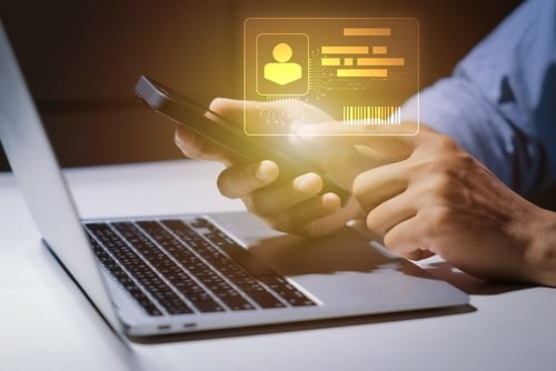 digital identity card hovering about a laptop and mobile phone